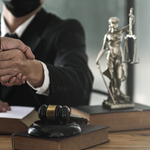 Lawyer shakes hands with employer after winning lawsuit.